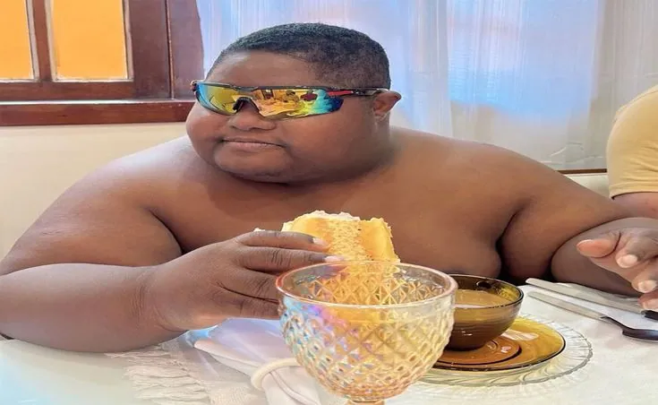 menino comculos escuros comendo