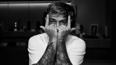 Homem tatuado cobrindo o rosto