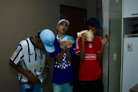 Jovens com camisas de time e dinheiro