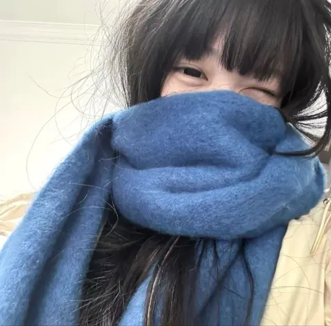 Garota estilosa com cachecol azul e óculos
