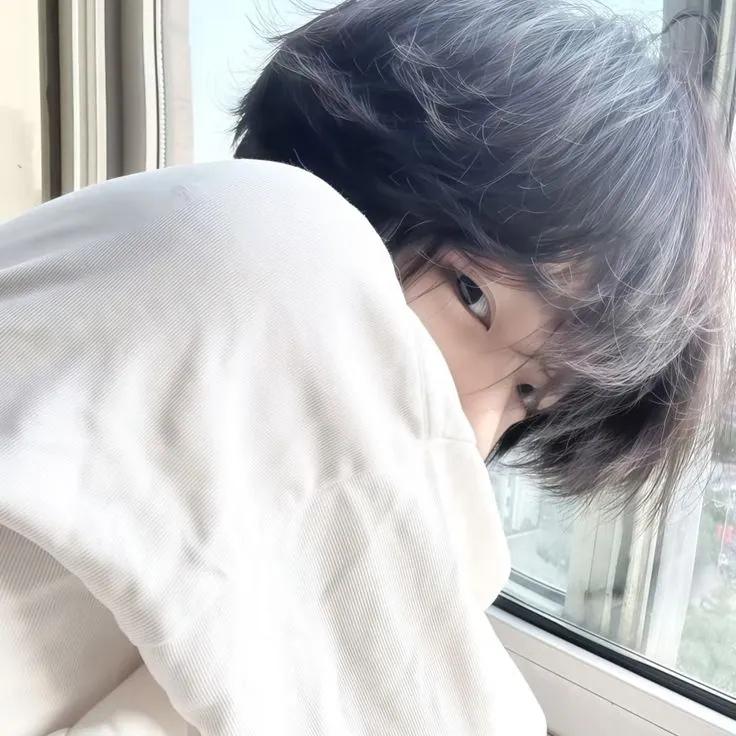 Jovem com cabelo escuro escondendo rosto