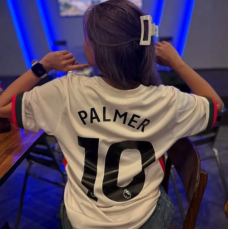 Garota de costas com camisa de futebol