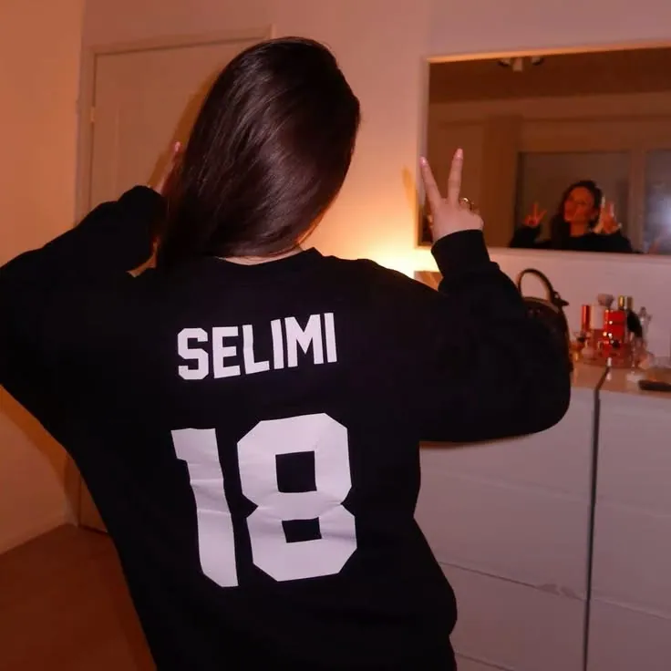 Garota de costas com camisa de futebol